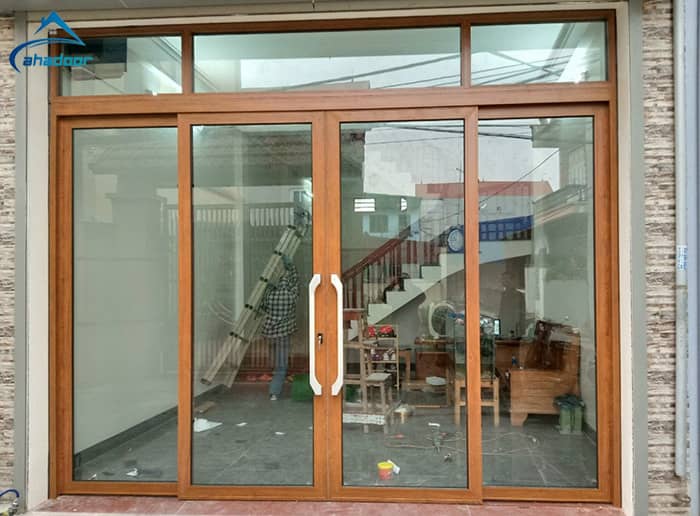 Lắp đặt cửa nhôm màu gỗ trượt quay mặt tiền nhà đẹp