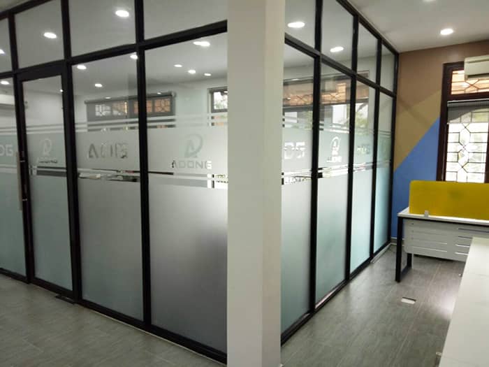 Sử dụng mẫu giấy dán mờ kết hợp logo cho vách kính phòng khách đẹp ấn tượng